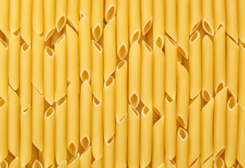 Italian uncooked pasta penne sorted vertically for background or texture.