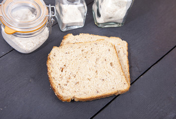 Gluten free bread with spelled flower on black wooden background