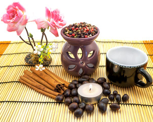 Tea ceremony by candlelight with cinnamon, roses, cup, pepper mix isolated on white