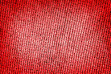 Red fabric woven texture macro background high contrasted with vignetting effect