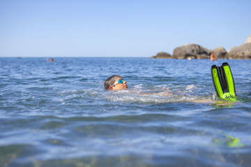 Fototapeta na wymiar Happy laughing boy swimming in the sea