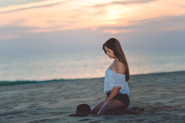 Fototapeta na wymiar Beautiful female sitting on sandy beach