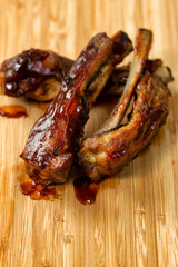Freshly cooked BBQ ribs with sauce on wooden board