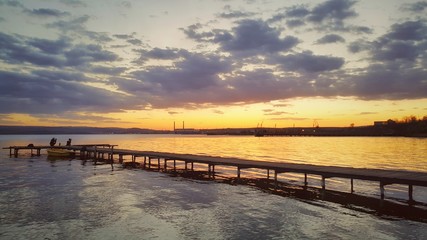 Fototapeta premium Beautiful sunset over the lake and sea jetty