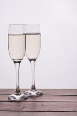 Champagne glass on wooden table against white background