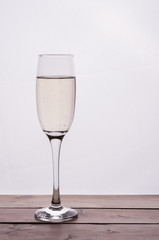 Champagne glass on wooden table against white background