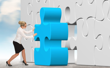 business woman building a blue puzzle on a sky background

