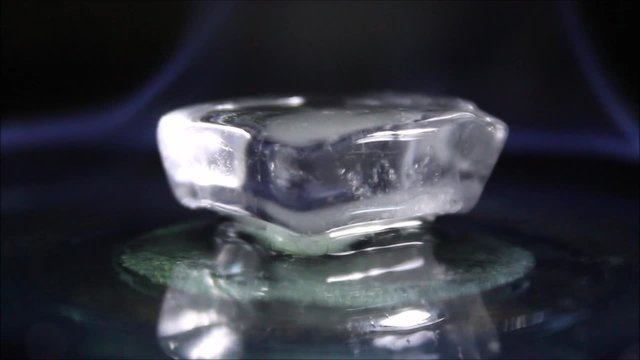 Burning ice cube in the dark closeup