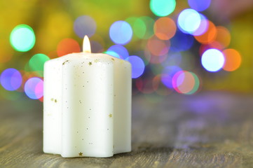 paląca się biała świeczka na tle magicznego bokeh © Darios