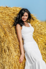Brunette woman near hay bale