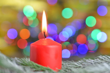 paląca się czerwona świeczka na tle magicznego bokeh © Darios