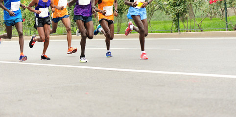Marathon runners rumnning on city road