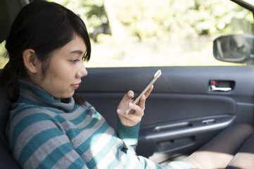Women look at the smart phone in the car
