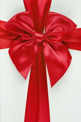 Red ribbon with bow as gift on white background