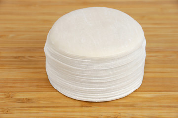 dumpling wrappers on bamboo chopping board