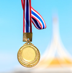 old gold medal on blue background, soft focus and blank face for