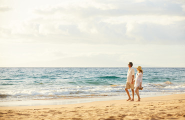 Mature Couple Walking on the Beach at Sunset