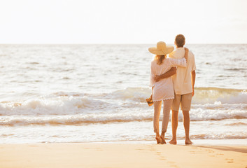 Mature Couple Walking on the Beach at Sunset