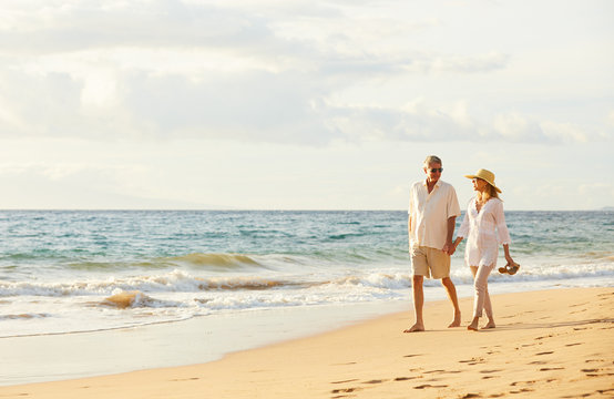 Mature Couple Walking on the Beach at Sunset - Powered by Adobe