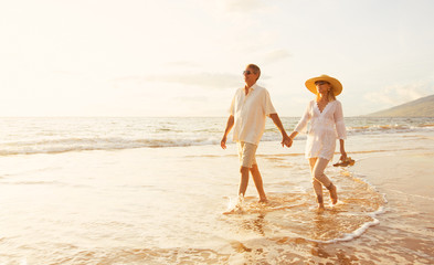 Mature Couple Walking on the Beach at Sunset