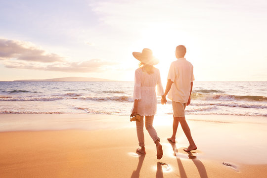 Mature Couple Walking on the Beach at Sunset