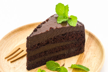 Chocolate cake slice in wooden plate.