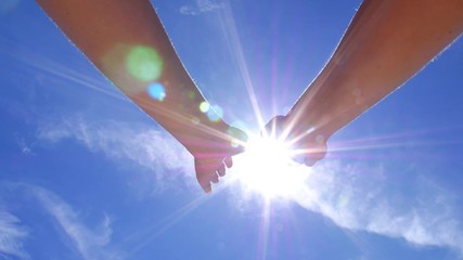 Hands Touching the Sun in Blue Sky