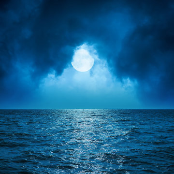 Full Moon In Clouds Over Dark Blue Sea