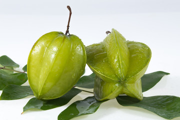 Star fruit with green leaf isolate on white background .
