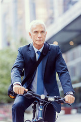 Fototapeta premium Successful businessman riding bicycle
