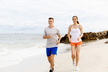 Fototapeta premium Runners. Young couple running on beach