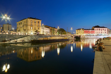 Fototapeta na wymiar Milan new Darsena, redeveloped docks area in the night, people