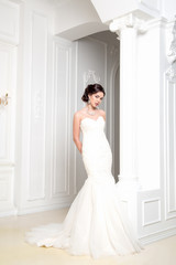 Fototapeta premium Beautiful sensual brunnete with elegant hairstyle. Wedding dress