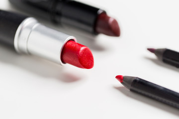 close up of two open lipsticks and lip pencils