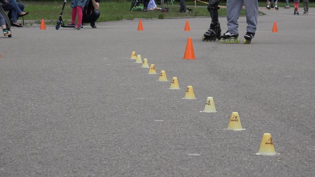 unidentified sportsman with roller skate ride style slalom element with cone in stadium. 4K UHD video clip. Roller skater sport day. 
