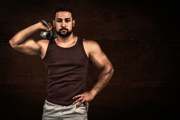 Fototapeta na wymiar Composite image of muscular serious man holding a kettlebell