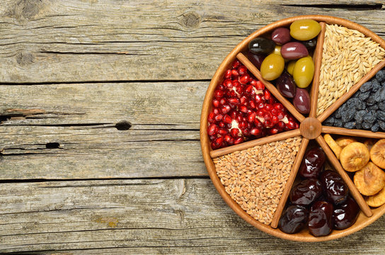 Dried fruits,barley,olives and wheat - symbols of judaic holiday Tu Bishvat. Copyspace background.
Top wiew.
