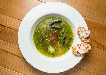 Serving  spicy fish soup Thai style  on top of brown wooden table