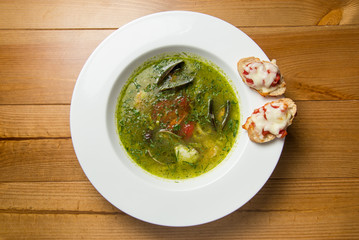 Serving  spicy fish soup Thai style  on top of brown wooden table