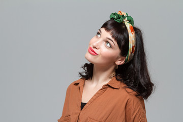 Cute lovely young female dreaming and looking up