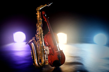 Fototapeta premium Beautiful golden saxophone with violin on a scene