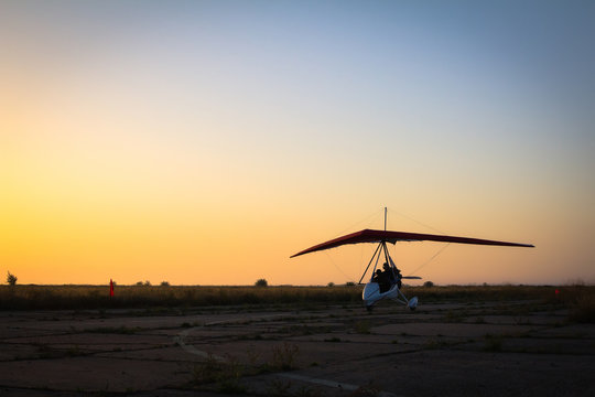 Hang-gliding, standing at dawn on the runway