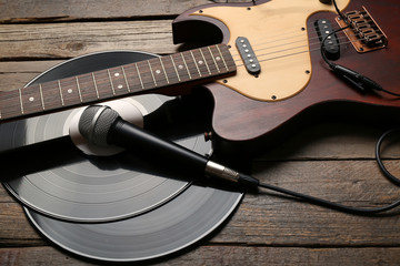 Electric guitar and headphones with vinyl on wooden background