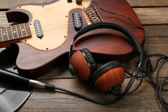 Electric guitar and headphones on wooden background