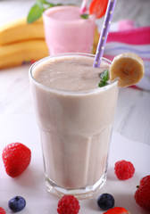 Milkshakes with berries on light wooden background, close-up