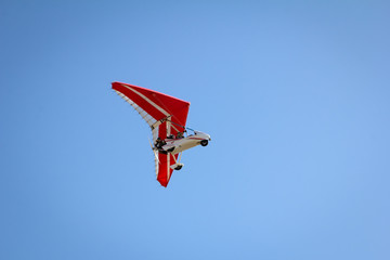Motorized hang glider soaring in the blue sky