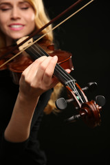 Fototapeta premium Musician plays violin on black background, close up
