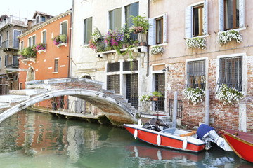 Fototapeta na wymiar Charming corner of a canal in Venice (Italy), with a bridge and several small boats