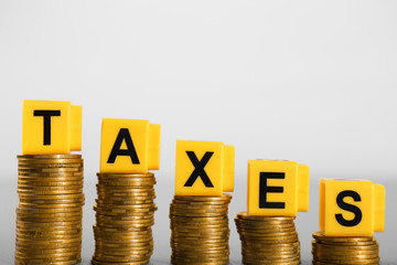 Alphabet TAXES and golden coins on table