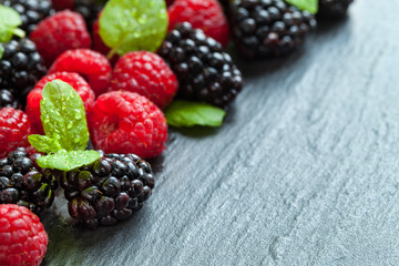 Heap of raspberry and blackberry on stone